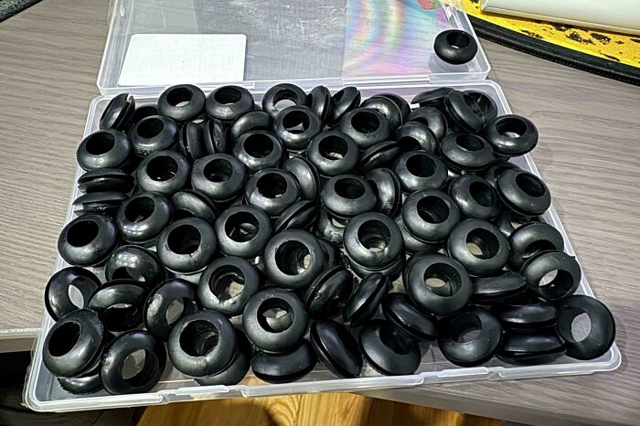 Black licorice pieces piled in a clear plastic container, illustrating one of the forbidden foods to resist eating.