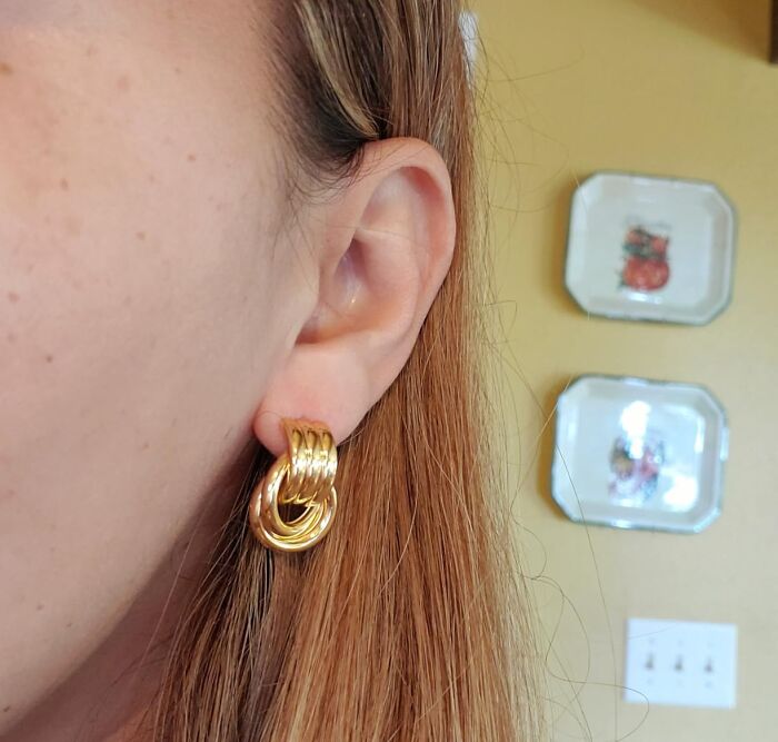 Close-up of a person wearing gold hoop earrings, showcasing a stylish accessory featured in Alix Earle’s Amazon Black Friday deals.