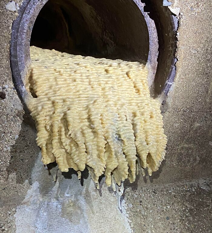 Drainpipe clogged with congealed yellowish substance representing one of the forbidden foods to avoid eating.