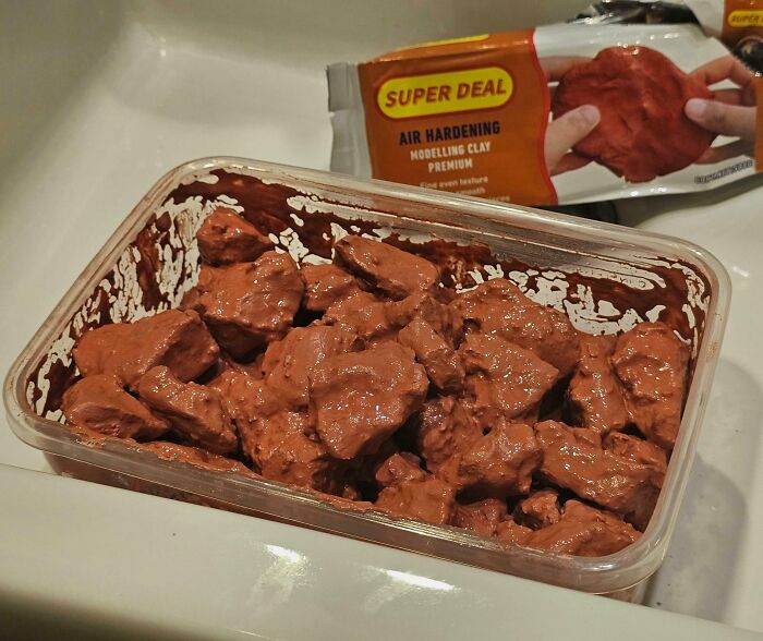 Container filled with air hardening modeling clay chunks, illustrating a concept of forbidden foods to avoid eating.