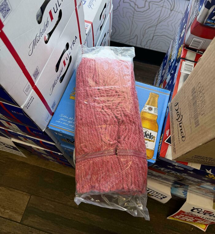 Red meat wrapped in plastic sitting on top of beer boxes, one of the forbidden foods to resist eating.