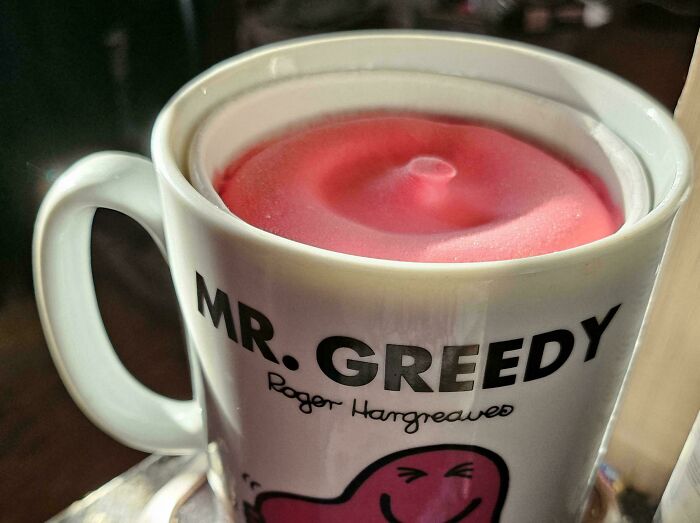 Close-up of a Mr. Greedy mug with perfectly aligned pink foam surface, illustrating things aligned so perfectly.