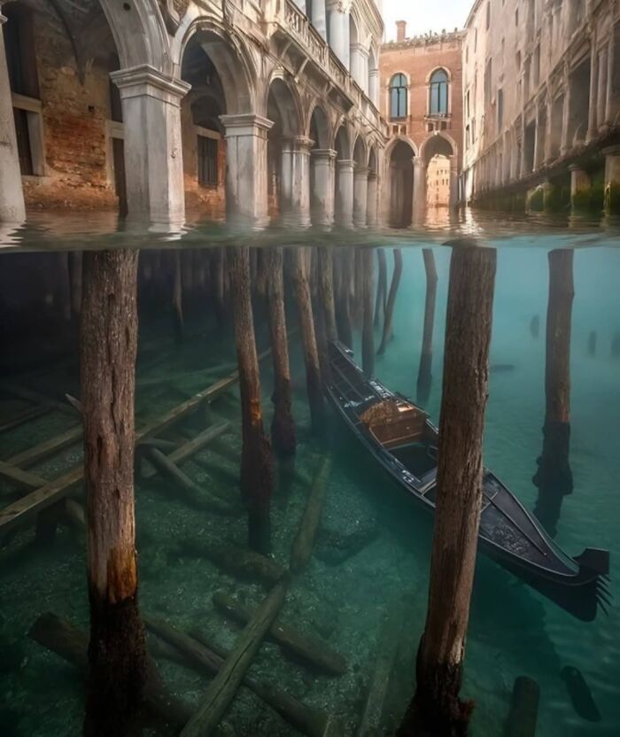 Venetian gondola floating over submerged wooden beams in clear water, showcasing strange and unique world facts.