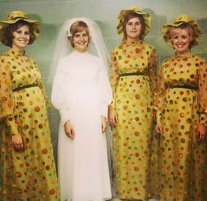 Bride in a traditional wedding dress standing with three bridesmaids in matching polka dot dresses and hats showing questionable taste
