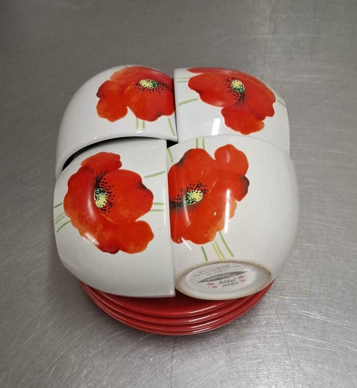 Four ceramic bowls with red poppy flowers perfectly aligned to form a complete floral design on the surface.