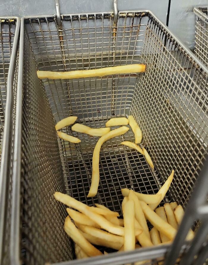 French fries perfectly aligned inside a fryer basket, illustrating things aligned so perfectly in everyday moments.
