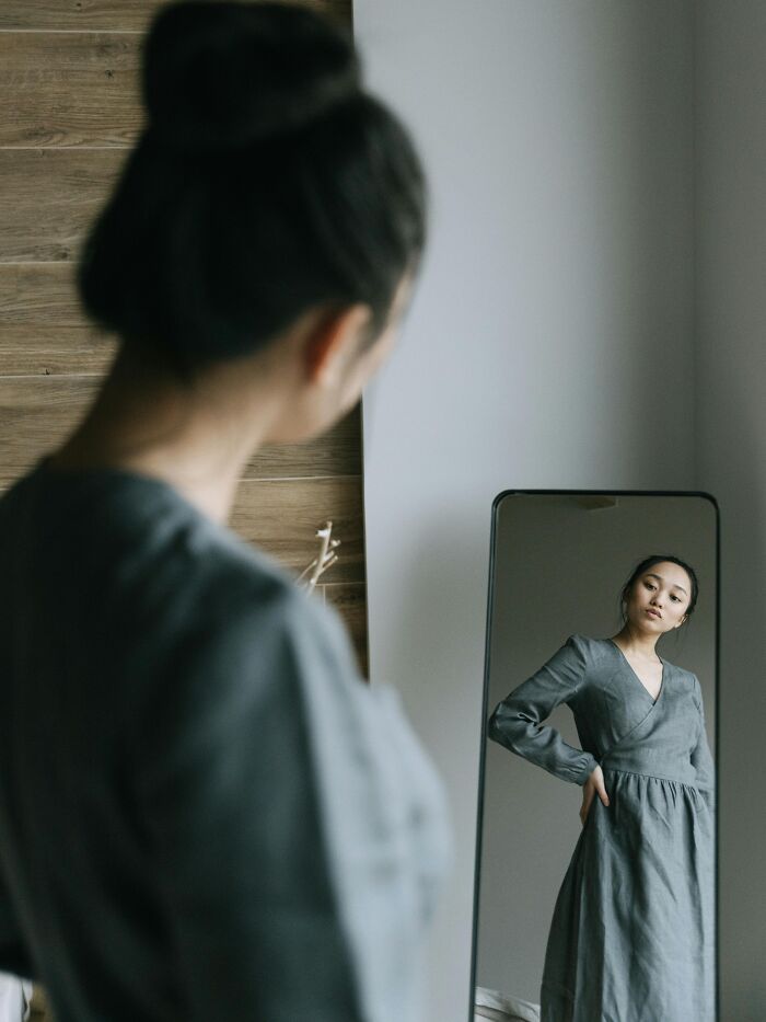 Woman looking at herself in a mirror, reflecting on relatable moments we’re all probably guilty of experiencing.