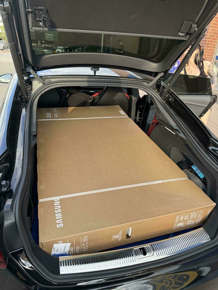 Large Samsung TV box fitting perfectly inside a car trunk, showcasing things aligned so perfectly with no wasted space.