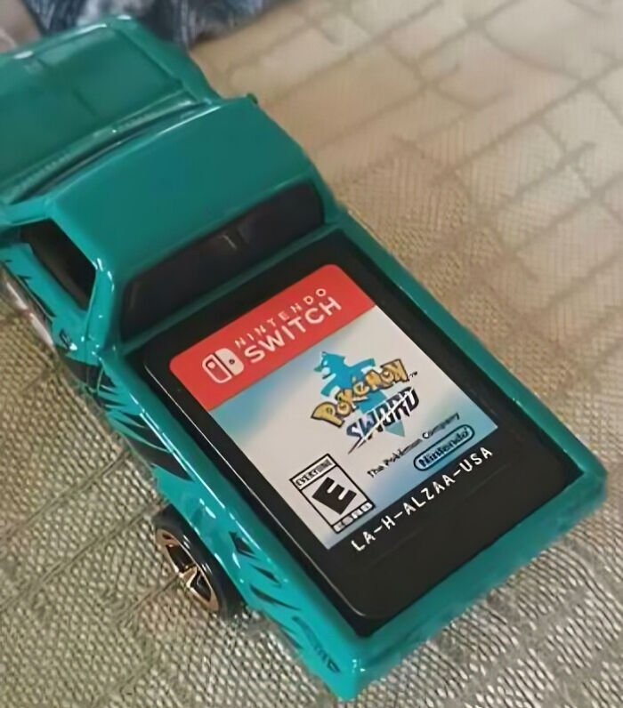 Toy car with a Nintendo Switch Pokemon game cartridge perfectly aligned on its roof, illustrating things aligned perfectly.