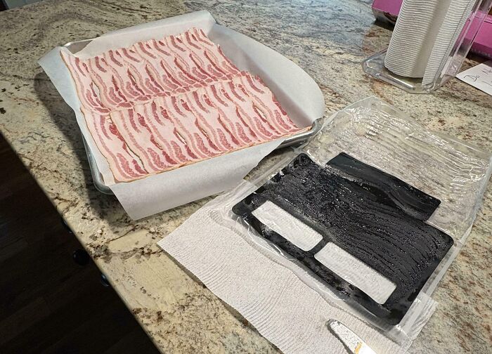 Slices of bacon perfectly aligned on parchment paper next to an empty plastic tray on kitchen counter.