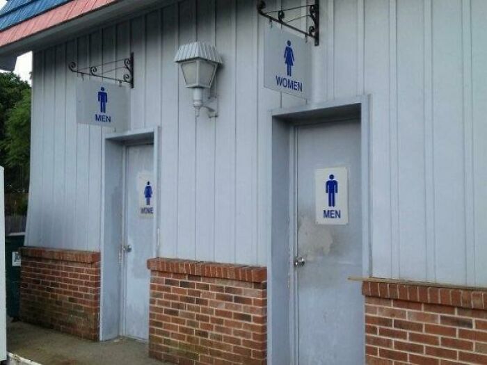 Mismatched restroom signs showing poor job e*******n with men and women labels incorrectly placed on doors.