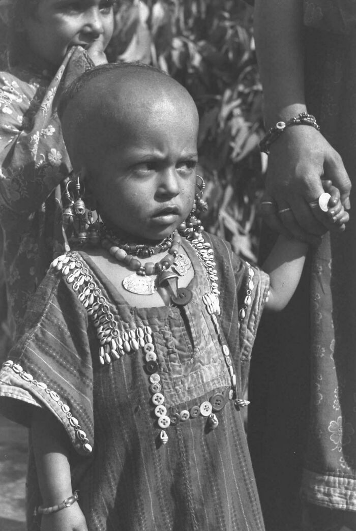 Young child wearing traditional jewelry and clothing, captured in a portrait highlighting human beauty and diversity.