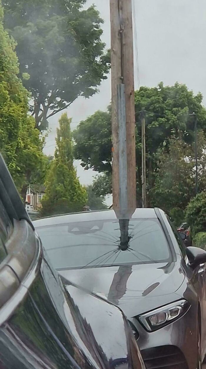 A utility pole appears to pierce a car windshield, creating a confusing photo that challenges the brain.