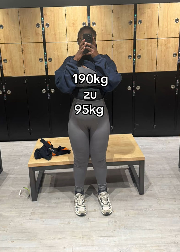 Woman showing weight loss transformation in gym locker room using a belly band to hide loose skin after massive weight loss.