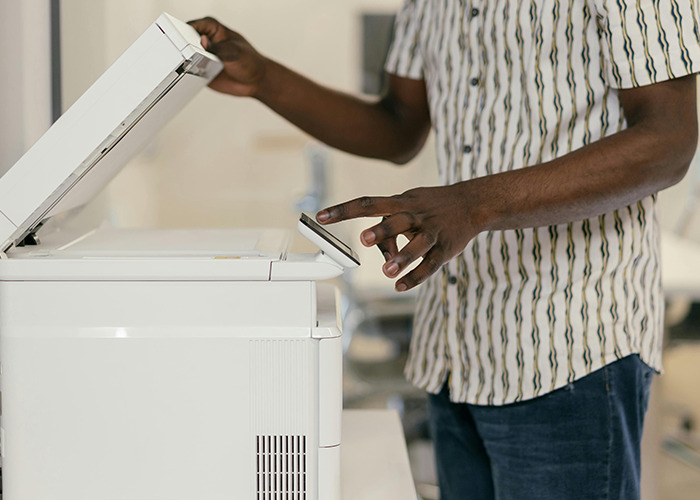Person using a copier machine, illustrating one of the horrible gifts people have actually received in an office setting.