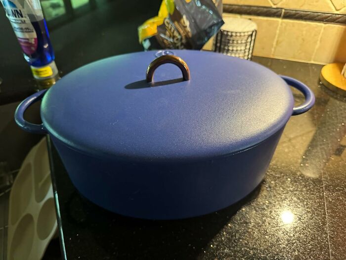 Blue enameled cast iron Dutch oven with lid on a kitchen counter, featured in Black Friday kitchen deals.