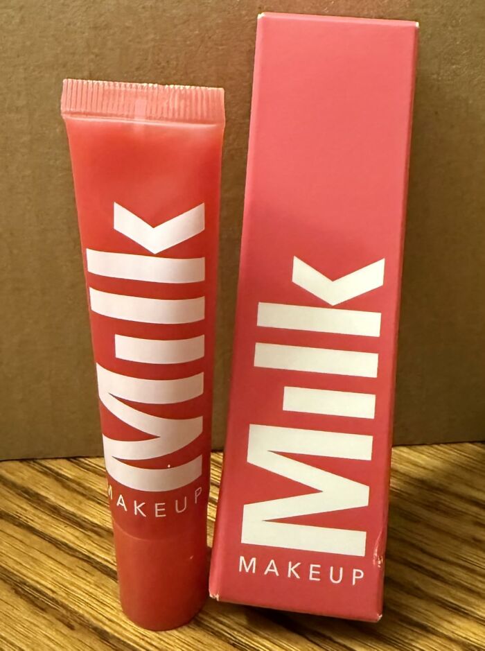 Milk Makeup product tube and box in coral color placed on wooden surface, featured in Alix Earle’s Amazon Black Friday deals.