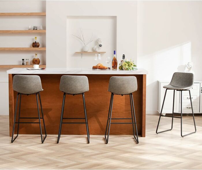 Modern kitchen with wooden island, four gray bar stools, and Black Friday kitchen deals on display.