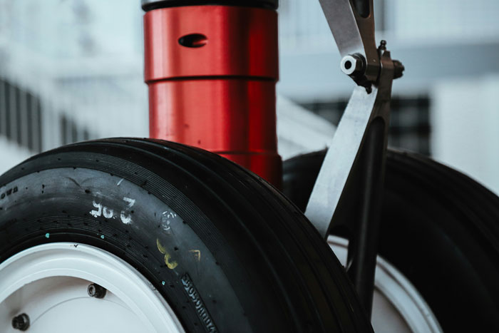 Close-up of airplane landing gear wheels and struts highlighting critical components in mid-flight safety and close calls.