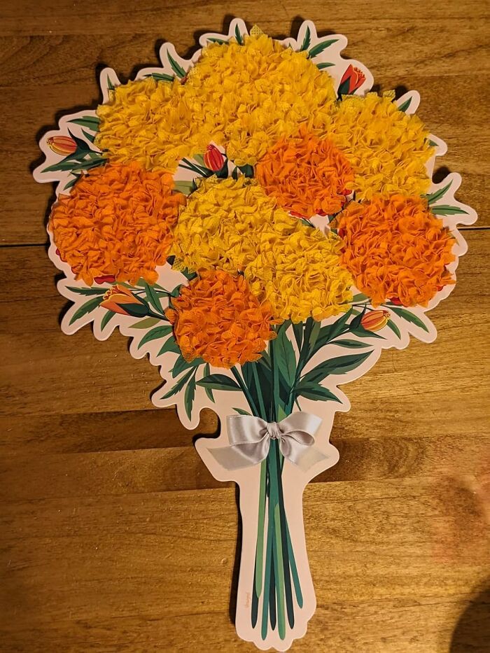 Paper craft bouquet with orange and yellow flowers, a white ribbon, showing a creative hobby to keep hands busy during hibernation season.