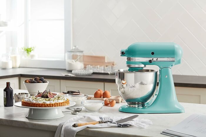Kitchen countertop with a turquoise stand mixer, pie, eggs, and baking ingredients showcasing Black Friday kitchen deals.
