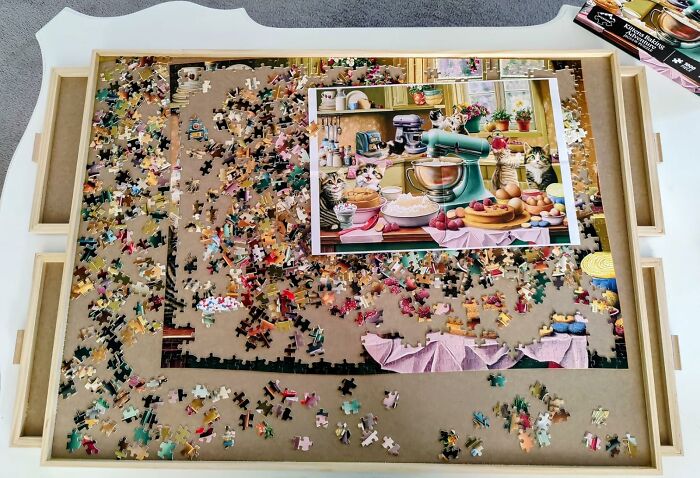 Unfinished cat-themed jigsaw puzzle on white table top with scattered pieces, representing Cyber Monday deals excitement.