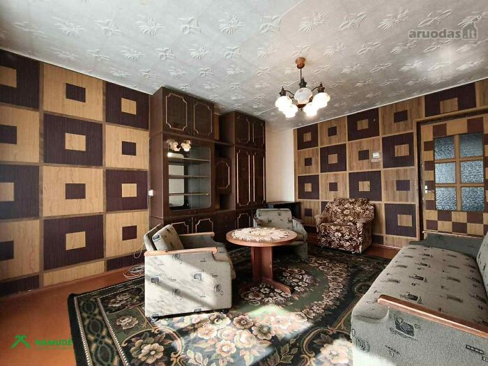 Living room with vintage furniture and patterned walls in a wild real estate listing with unique interior design.