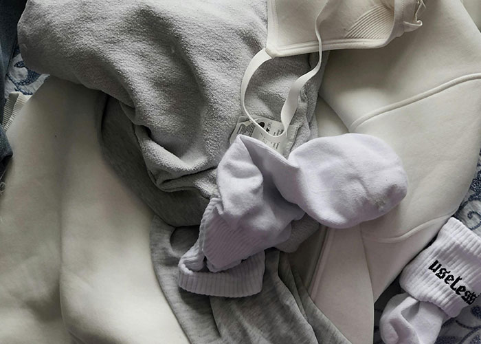 Pile of laundry with socks and clothing items, illustrating genius cleaning hacks inspired by laziness.
