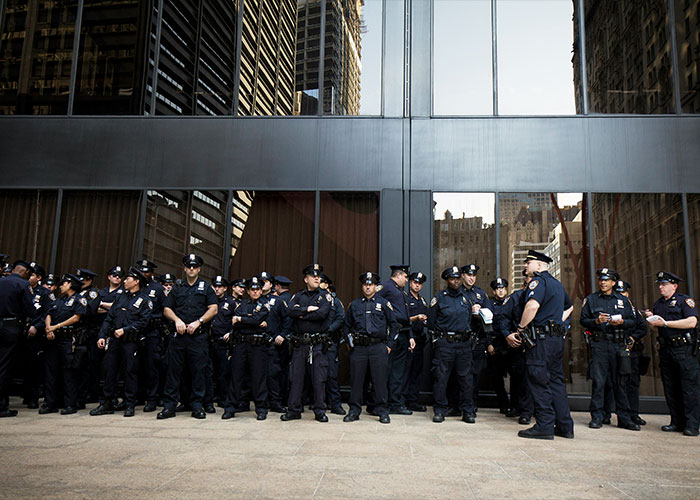 Group of police officers standing in front of a glass building, relating to trainee police officer lifetime ban news.