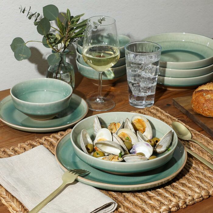 Green ceramic dinnerware set with seafood and drinks on a wooden table, ideal holiday shopping gift inspiration.