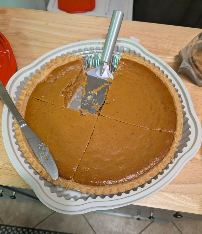 Pumpkin pie sliced with utensils on a kitchen counter, highlighting popular Thanksgiving arguments online.