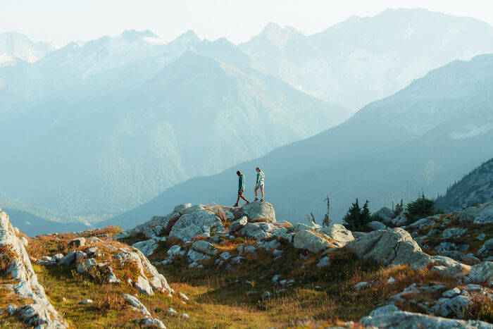 Two hikers exploring rocky terrain with mountainous background, symbolizing a journey to find purpose and direction. Two hikers exploring rocky terrain with mountainous background, symbolizing a journey to find purpose and direction.