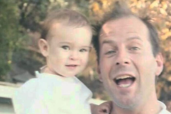Bruce Willis smiling and holding a baby outside, illustrating a family moment amid dementia update discussion. Bruce Willis smiling and holding a baby outside, illustrating a family moment amid dementia update discussion.