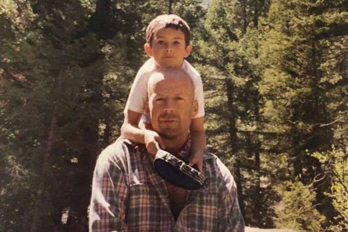 Bruce Willis with young child outdoors, capturing a family moment amid nature, relating to update on his dementia. Bruce Willis with young child outdoors, capturing a family moment amid nature, relating to update on his dementia.