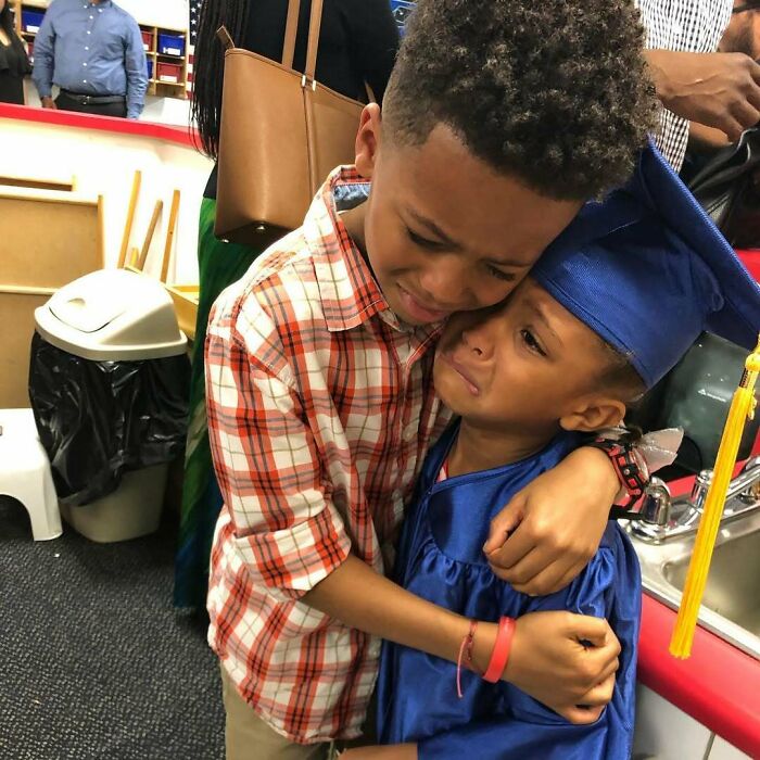 Two young siblings hugging tightly, showing deep emotion and gratitude during a graduation celebration moment.