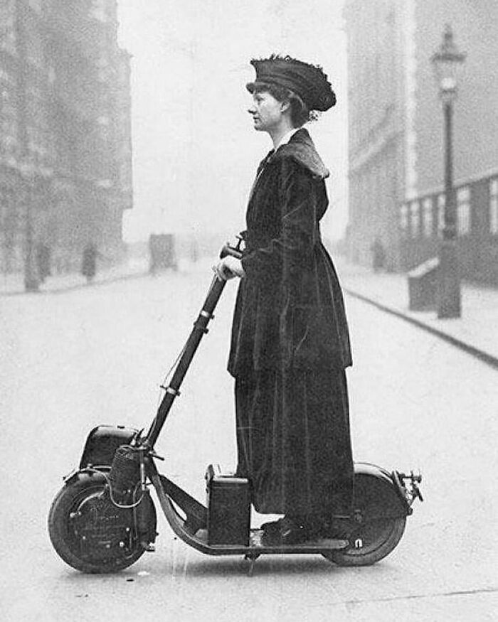Viktorya dönemine ait tuhaf fotoğrafları gösteren, şehrin sokaklarında erken dönem elektrikli scooter'ı üzerinde duran Viktorya dönemi kadını.