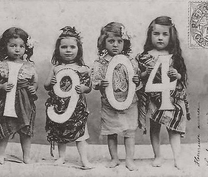 Four Victorian-era children holding large numbers forming 1904, a weird photo from the Victorian era.