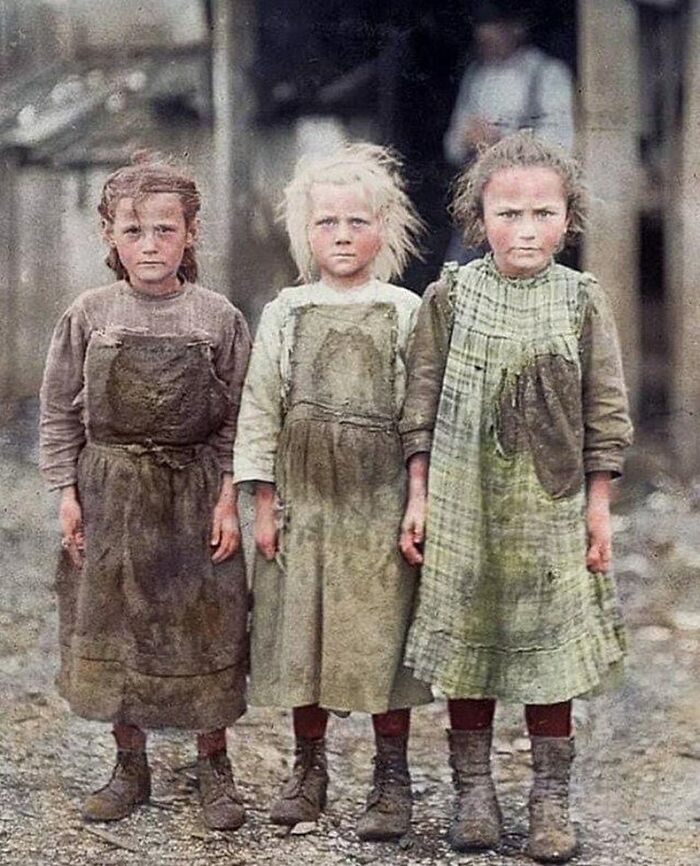 Three young girls in dirty Victorian-era clothing standing outdoors in a bleak setting, illustrating Victorian era life.