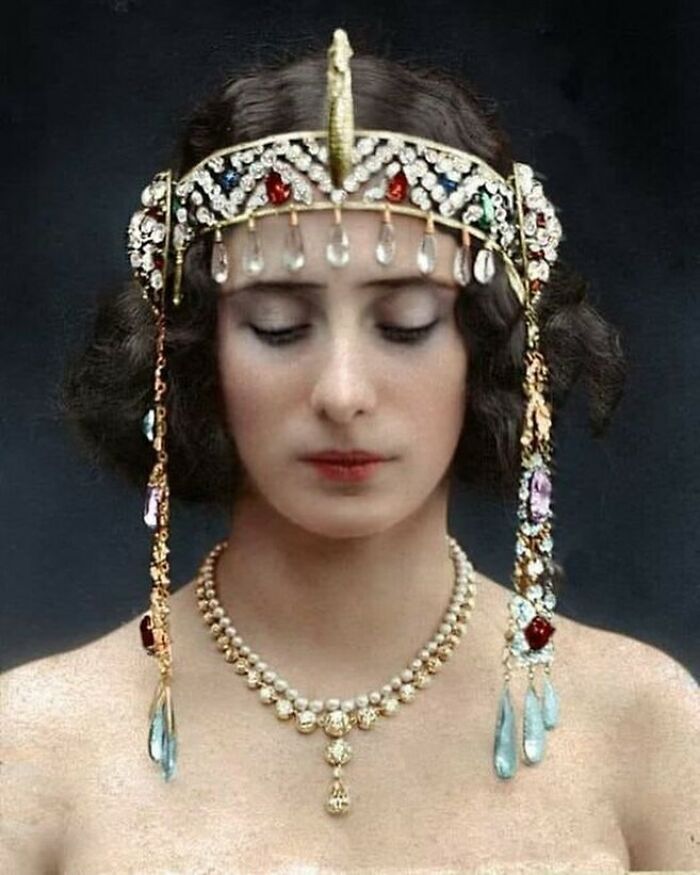 Victorian era woman wearing an elaborate jeweled headpiece and matching pearl necklace, showcasing period fashion and style.
