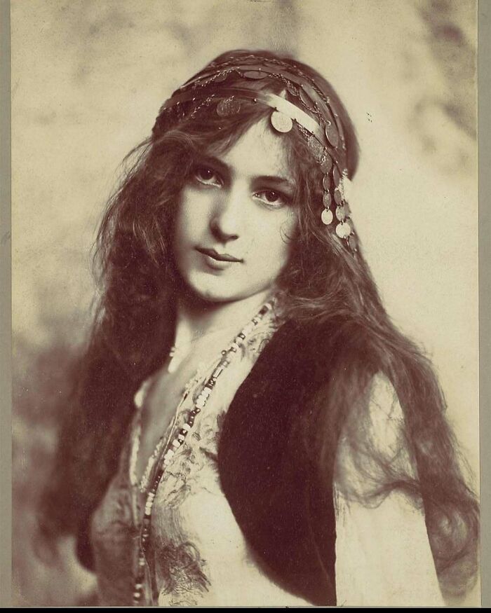 Victorian era portrait of a young woman with long hair wearing a headpiece and vintage clothing in a weird photo style.