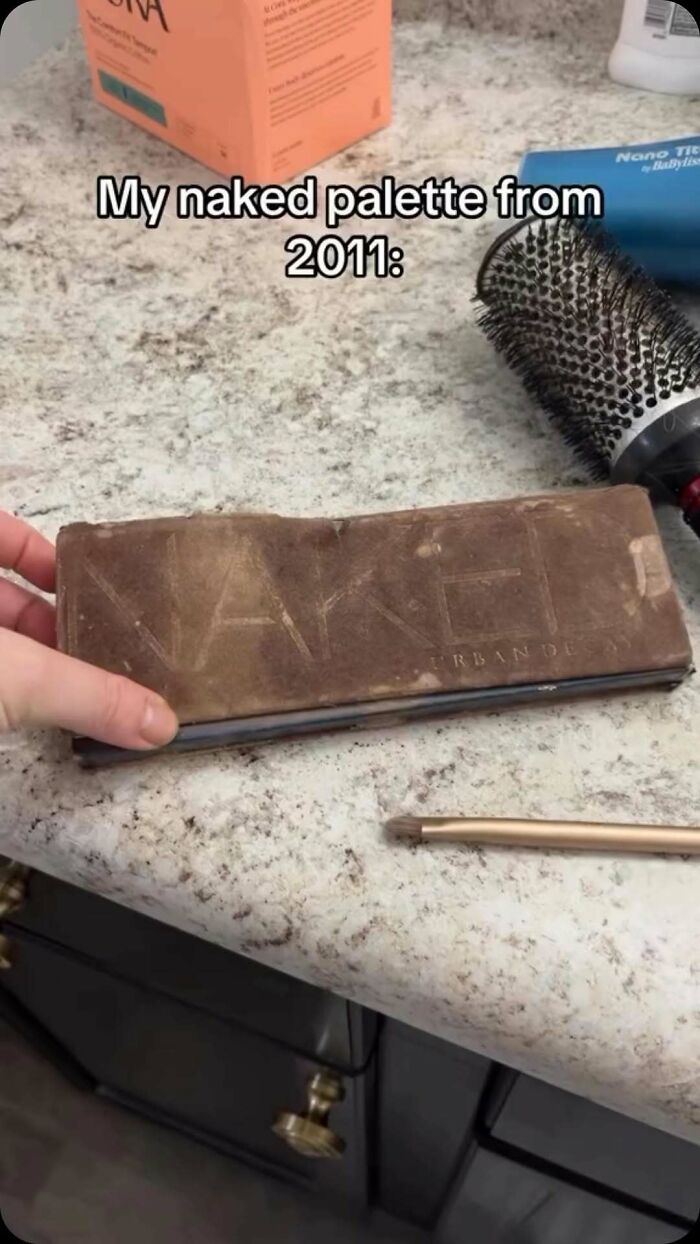 Worn vintage makeup palette from 2011 on bathroom counter with hairbrush and makeup brush nearby, fashion and diva life humor.