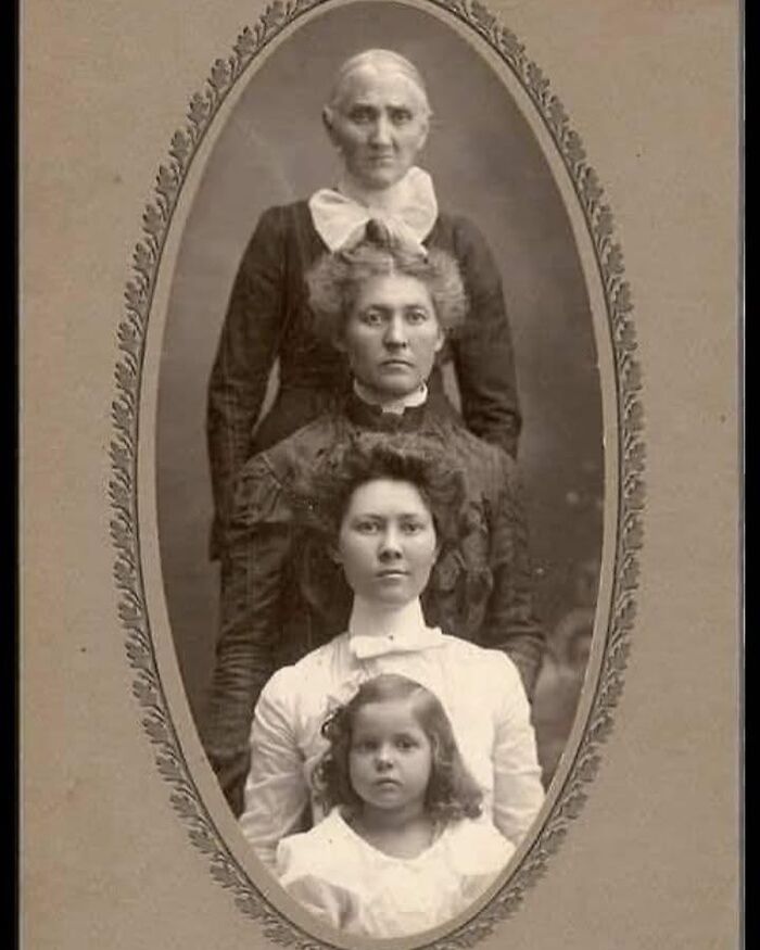 Victorian era weird photo of four females from different generations posed in a vertical, formal studio portrait.