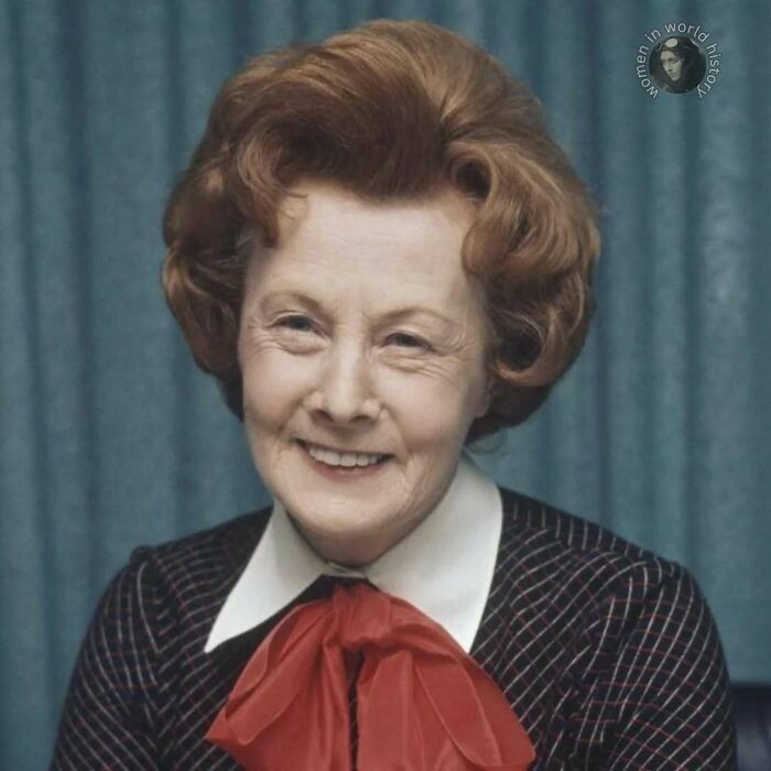 Portrait of an older woman with red hair smiling, representing women overlooked in history and their important achievements.