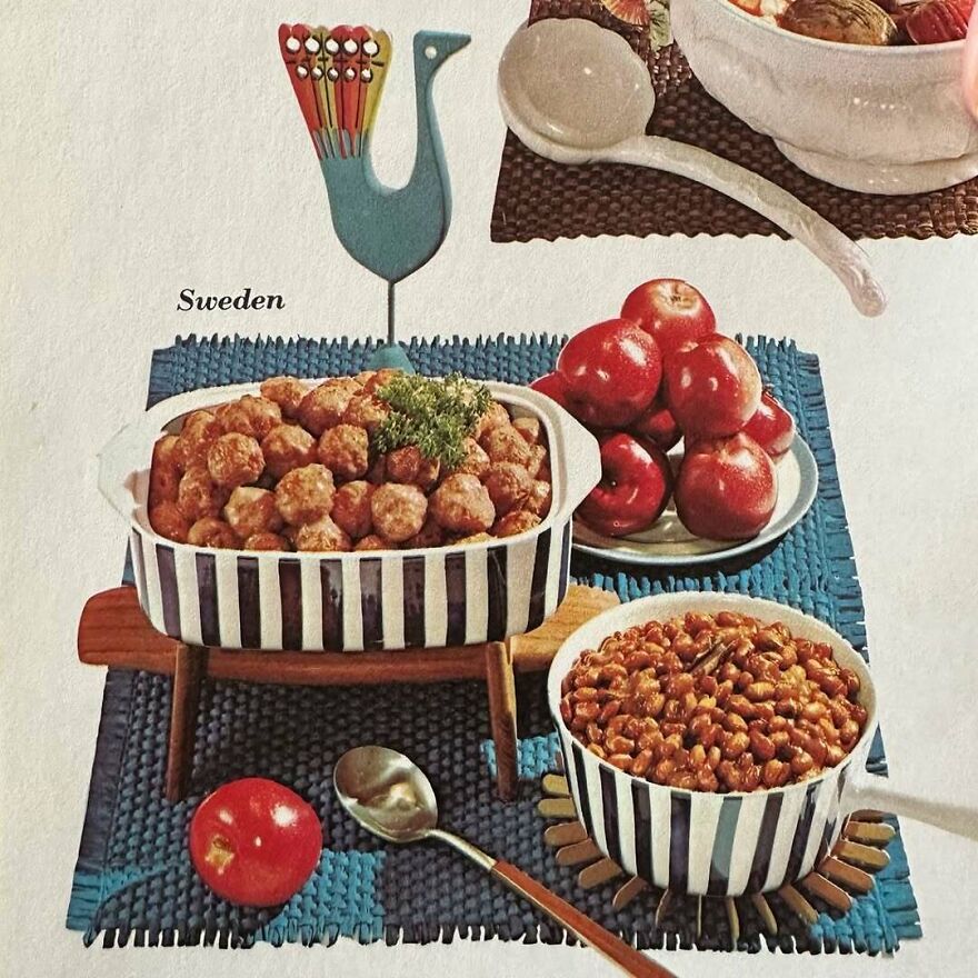 Vintage Swedish meatballs and baked beans served in striped dishes on a blue placemat with apples and decorative bird.