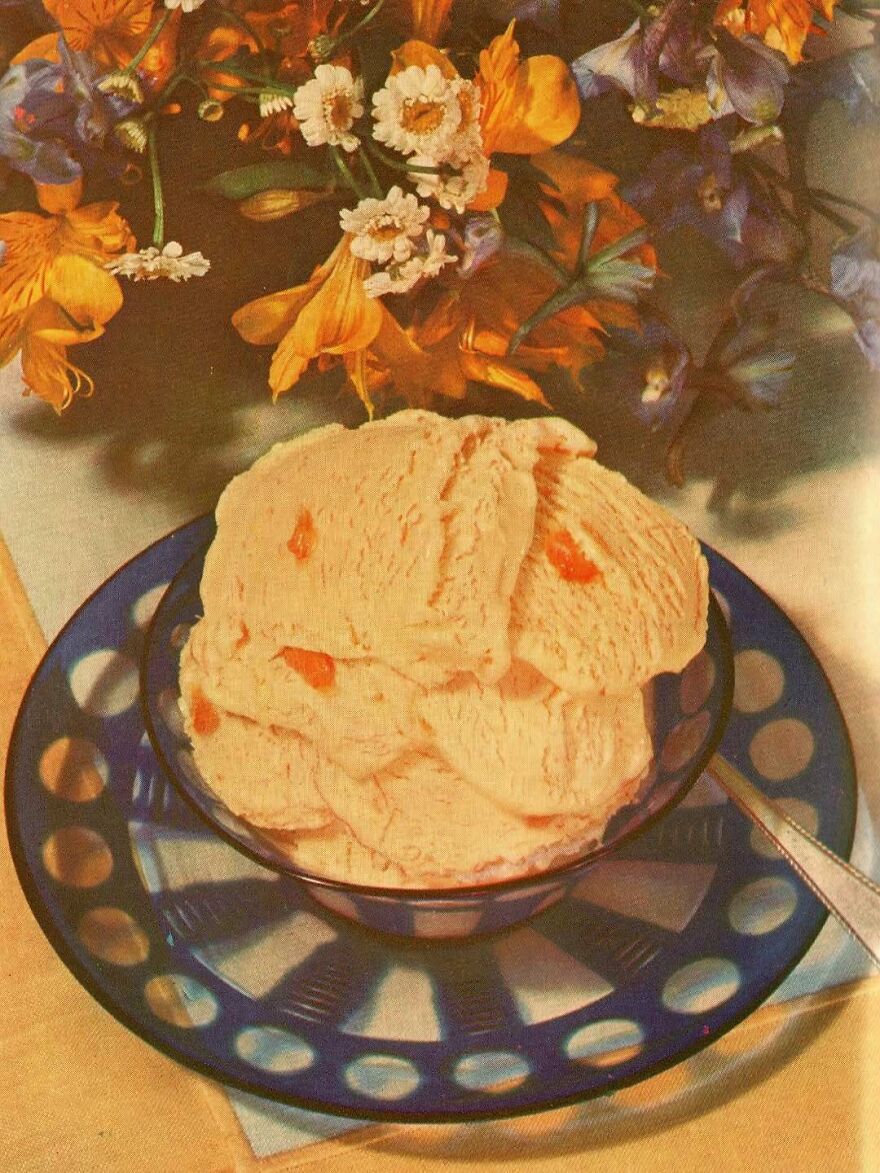 Vintage recipes ice cream served in a decorative bowl with colorful flowers in the background.