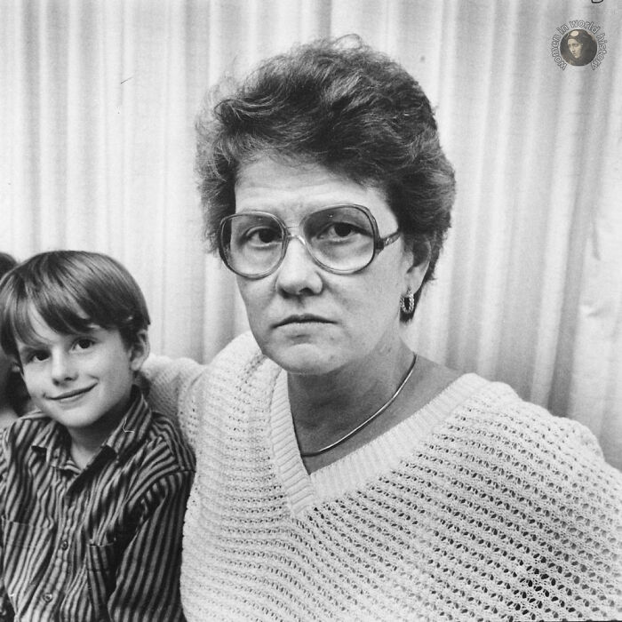 Black and white portrait of a serious woman wearing glasses next to a smiling child, highlighting overlooked women in history.