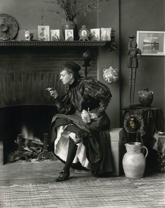 Historical black and white photo of a woman seated near a fireplace, representing overlooked women in history and their achievements.