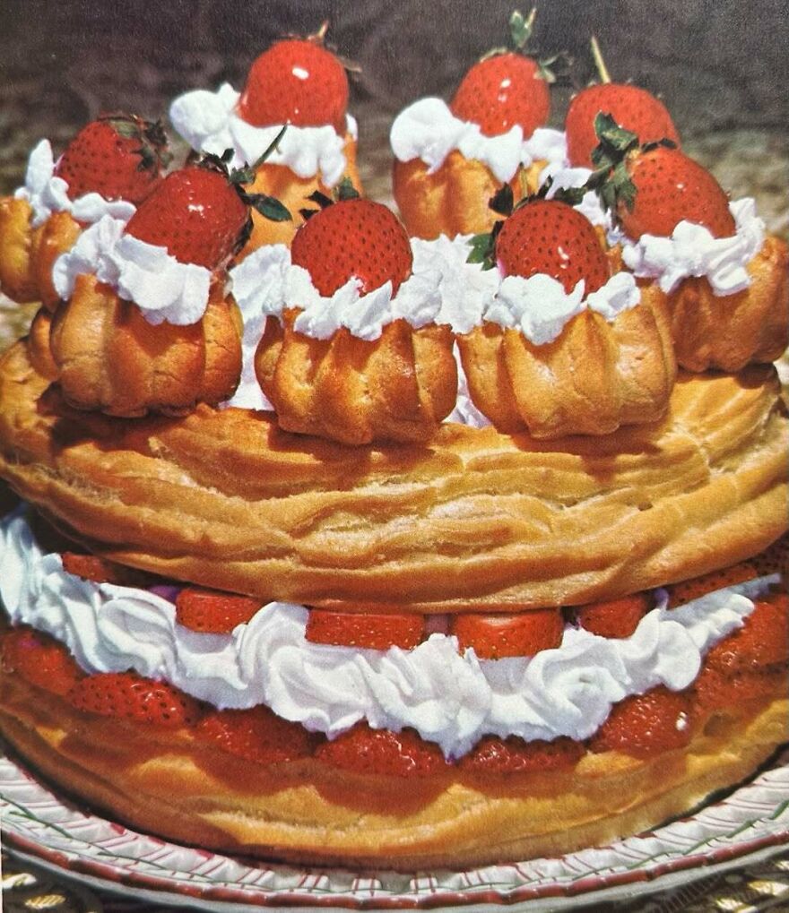 Vintage dessert featuring cream-filled pastries topped with strawberries and whipped cream, showcasing interesting vintage recipes.