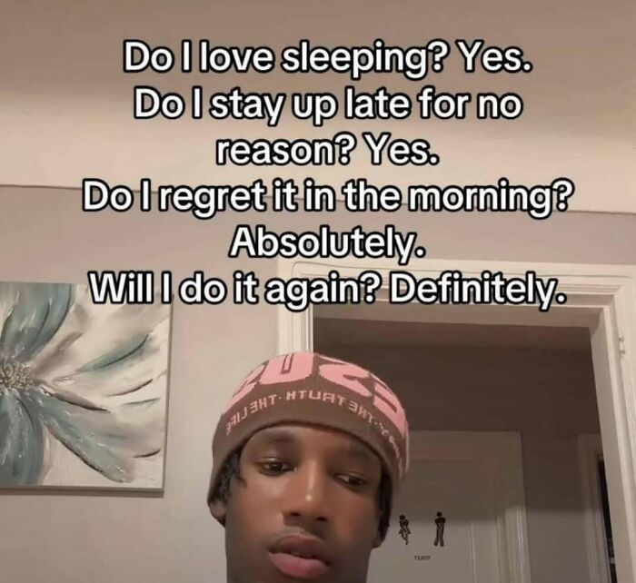 Young man wearing a pink beanie with a funny meme text about loving sleep and regretting staying up late.