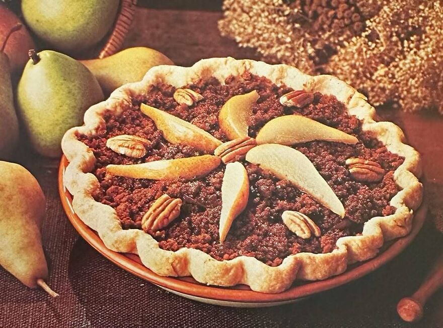 Vintage dessert pie topped with pecans and sliced pears, showcasing interesting vintage recipes and retro dish presentation.